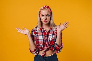 Image of displeased blonde pinup girl posing with trowing up hands