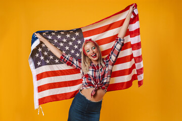 Image of happy pinup girl posing with american flag and smiling