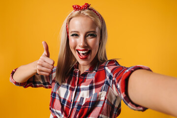 Image of cheerful pinup girl showing thumb up while taking selfie photo