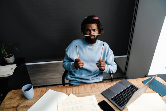 Young Funny Businessman Making Mustache With Pencil