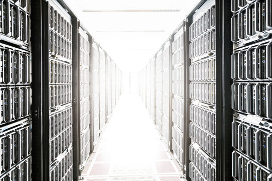 Very long isle between two banks of servers with a door blown ou
