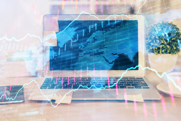 Financial graph colorful drawing and table with computer on background. Multi exposure. Concept of international markets.