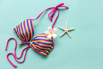 Fototapeta premium Summer items and accessories traveler woman colorful bikini with flower frangipani to travel plan holiday vacation in the beach. Tropical sea.