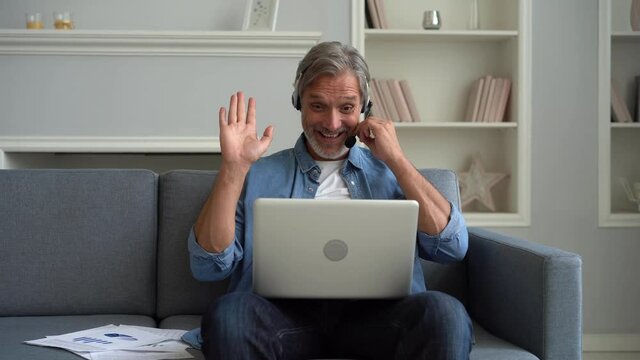 Employee of helpline technical support helps to client distantly through videocall, provide information to customer by virtual chat, man wear headset look at pc screen negotiating with client concept