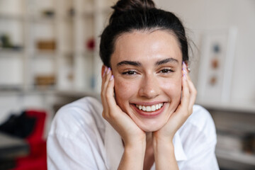 Beautiful positive woman sitting indoors in cafe