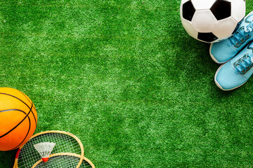 Frame of sport balls - football, basketball on football field. Copy space