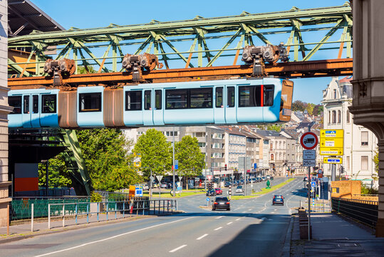 Schwebebahn Train crossing a street in Wuppertal, Germany. The Schwebebahn is the oldest electric elevated railway with hanging cars in the world and is a unique system in Germany. 