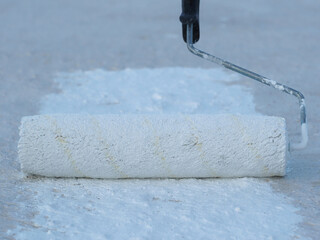 Close-up. Applying a waterproof coating to the roof with a roller.