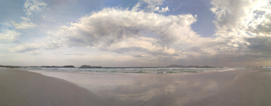 Panoramic view to the beach with stunning cloudy sky above it
