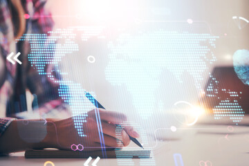 Multi exposure of hands making notes with world map hologram and data theme icons. Concept of...