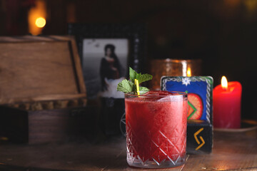 Fresh red berry cocktail with mint among witch decor and candles