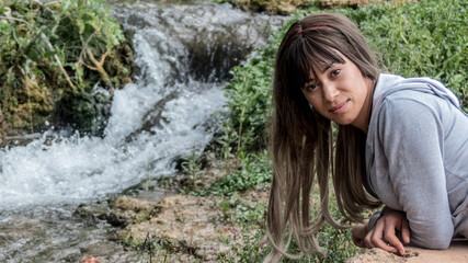 Mujer joven disfrutando de una hermosa catarata de las lagunas de ruidera.