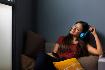 Woman listening music while relaxing at home	