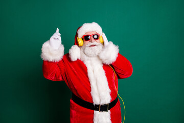 Portrait of his he nice attractive handsome cheerful Santa father listening different pop music soul jazz bass single having fun enjoying dancing isolated over green color background