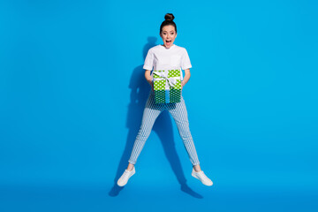 Full size photo of astonished positive girl jump hold big green gift box get receive 14-february 8-march anniversary wear good look white t-shirt isolated bright shine color background