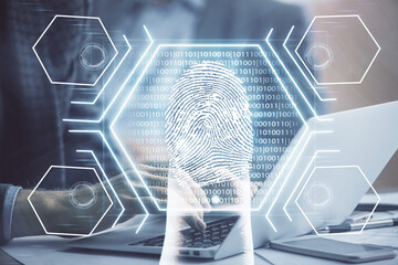 Fingerprint hologram with businessman working on computer on background. Security concept. Double exposure.