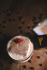 Spicy coffee sour cocktail with a large ice cube and lips decor next to the runes in a mystical restaurant. Top view, flat lay