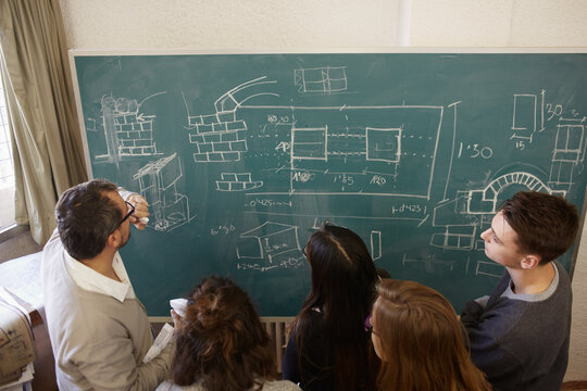 Professor with a group of students in front of the blackboard