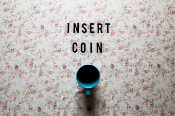 'insert coin' message on a empty cup of coffee