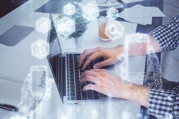 Technology theme hologram with man working on computer on background. High tech concept. Multi exposure.