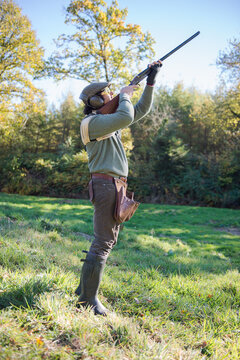 Hunter aiming his shotgun at a duck hunting in France