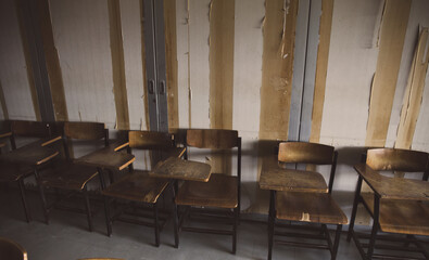 old wooden row lecture chairs in dirty classroom in poor school.study room without student.concept for education in third world ,donate and charity