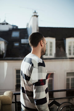 Portrait of a handsome man standing on a terrace in Paris
