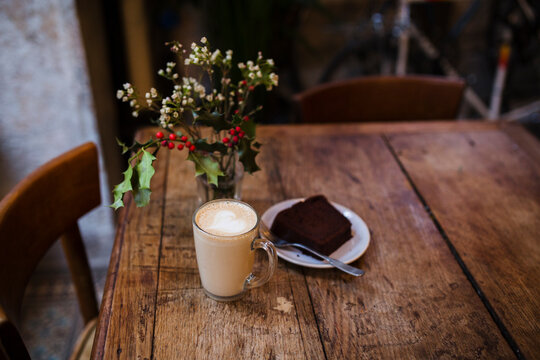 Coffee latte and piece of a chocolate cake on a wooden table