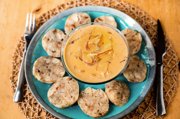 Forest mushroom sauce with dumplings on blue plate.