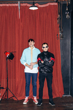 Not funny serious hooligans posing on red background 1990s style