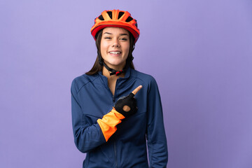 Teenager cyclist girl pointing to the side to present a product