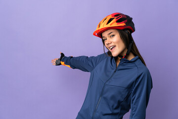 Teenager cyclist girl extending hands to the side for inviting to come