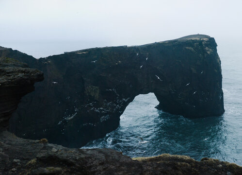 Misty cliff in sea - Powered by Adobe