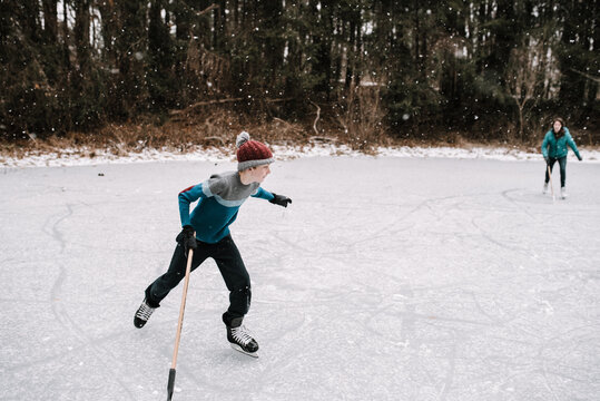 teeny skating with hockey stick in hand