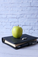black to school concept with apple on notepad on table.