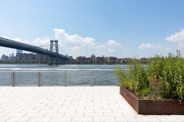 Domino Park Riverfront with the Williamsburg Bridge over the East River in Williamsburg Brooklyn...