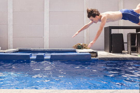 boy diving into backyard pool