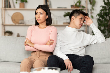 Asian Couple After Quarrel Not Talking Sitting Offended At Home - obrazy, fototapety, plakaty