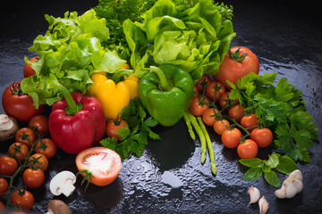 Set of fresh vegetables on black stone background. red yellow and green pepper, tomato, green oak, cos, Romaine, garlic, asparagus, mushroom and coriander with copy space.