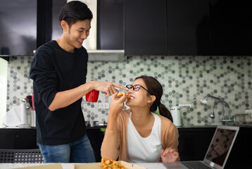 Asian couple teste together during eating pizza slice