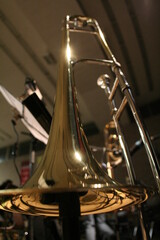 Detailansicht von goldenen Big Band Instrument Posaune. Trombone stand in frog perspective.