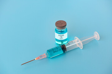 A concept of  against virus covid-19 corona virus,  a syringe with liquid vaccines  with blue background.