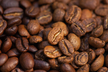 Mixture of different kinds of roasted coffee beans background.