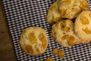 cornflakes cookies are placed on the cloth on the wooden table.