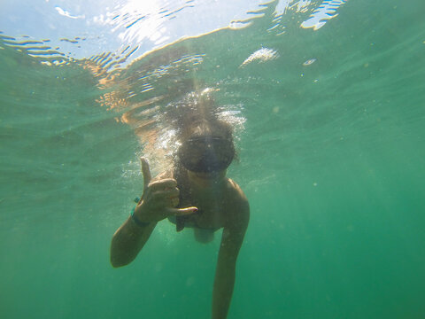 Girl getting a selfie with the go pro with goggles diving in the sea