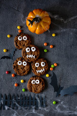 Modern Halloween background. Halloween cookies. Funny monsters made of biscuits with chocolate on the table. Halloween party decoration. Trick or treat concept.