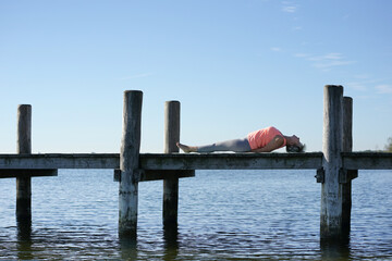 Frau in Yogapose am See