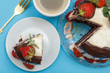 Homemade chocolate cake decorated with fresh strawberries and cup of coffee