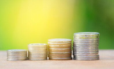 stack of coins on green nature background.