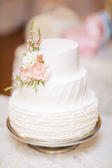 Fototapeta na wymiar White wedding cake decorated with living flowers. Fine art background.